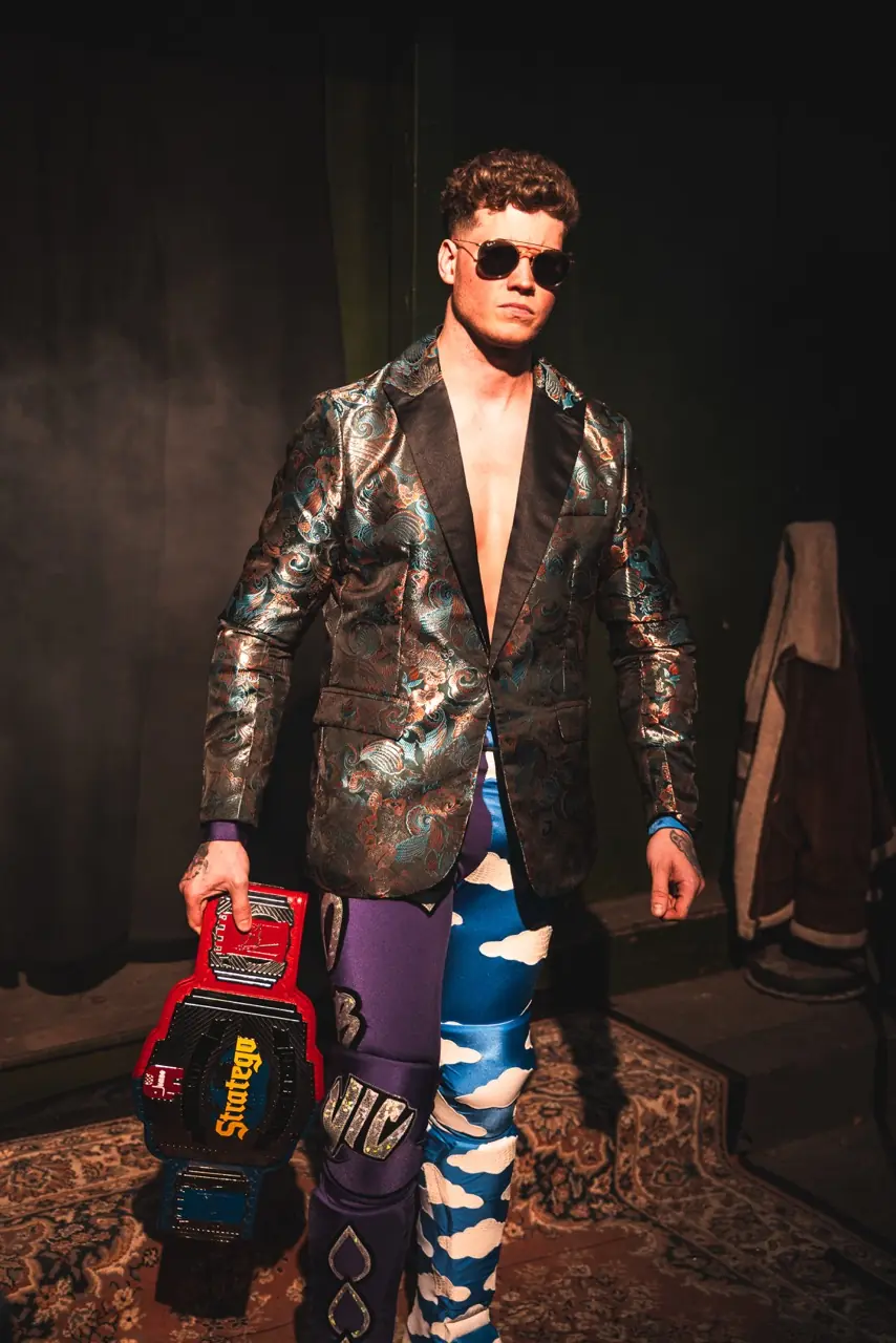 A wrestler carrying a championship belt